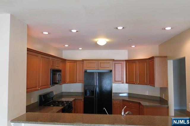 116 The Promenade, Unit 116 Edgewater, NJ 07020 - Photo 10 of 26 a kitchen with stainless steel appliances granite countertop a refrigerator and a sink