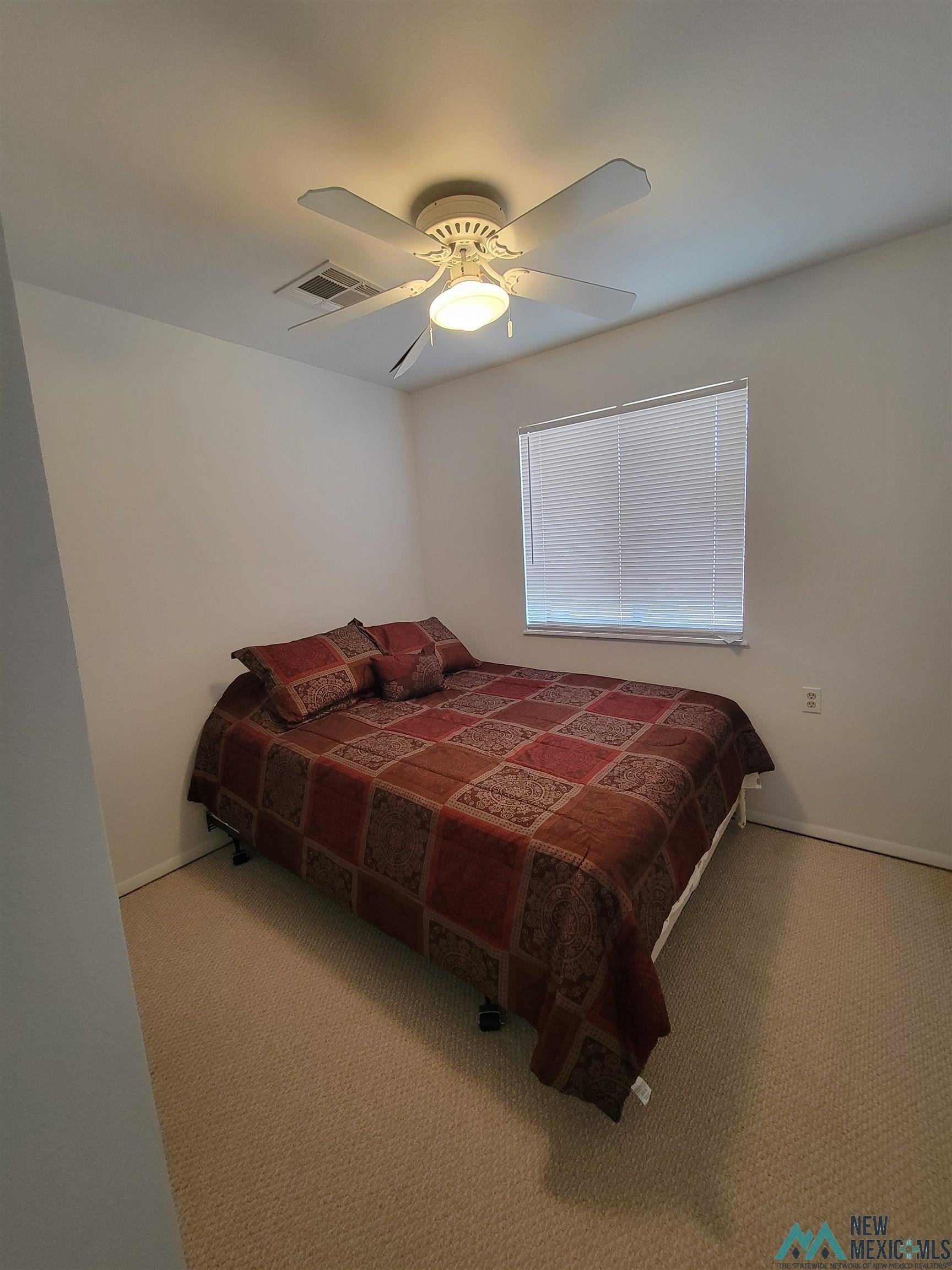 501 Springland Boulevard Elephant Butte, NM 87935 - Photo 19 of 38 Carpeted room featuring a ceiling fan with integrated lighting, a window with horizontal blinds, and neutral wall tones