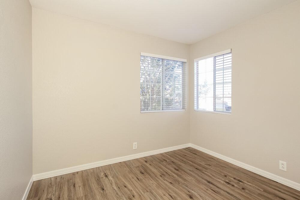 9243 West St John Road Peoria, AZ 85382 - Photo 12 of 17 an empty room with wooden floor and windows