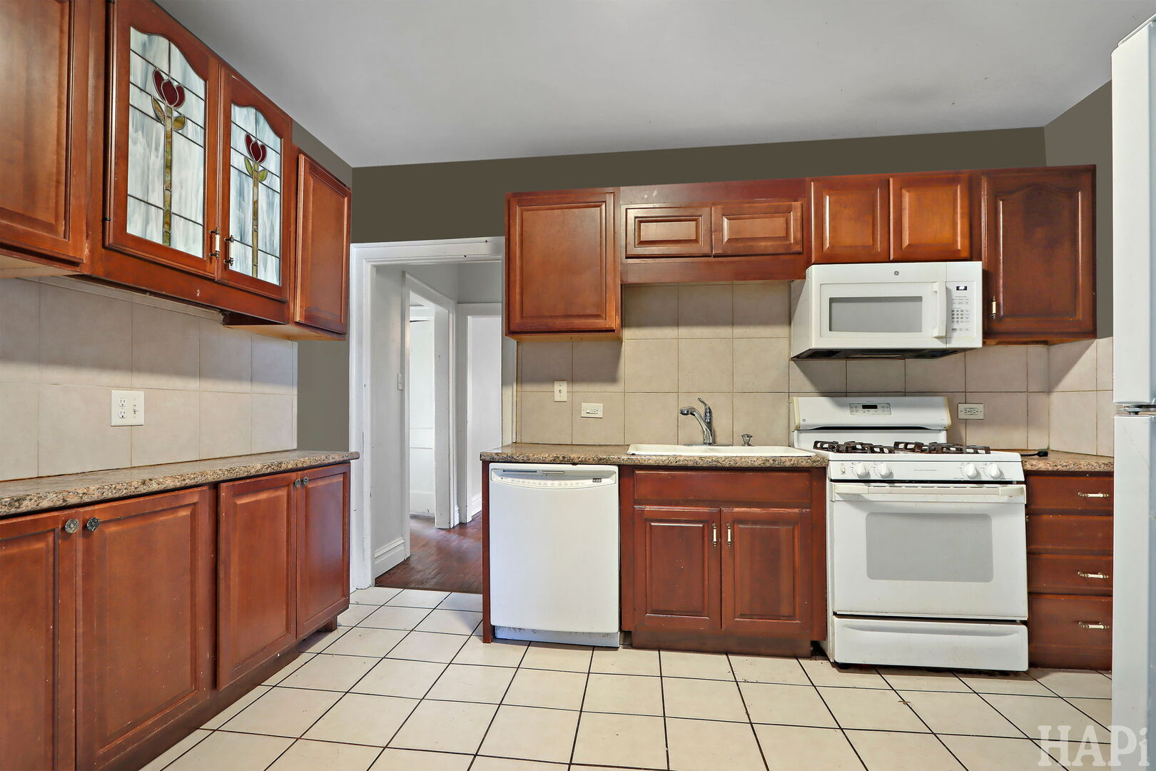 619 North Butrick Street Waukegan, IL 60085 - Photo 6 of 20 a kitchen with stainless steel appliances granite countertop a stove a sink and a microwave