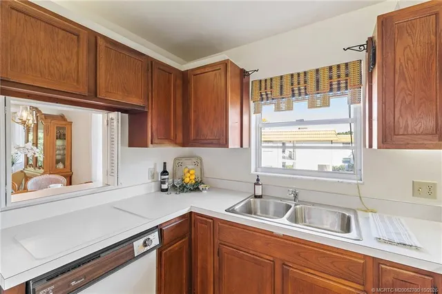 a kitchen with stainless steel appliances a sink a refrigerator and window