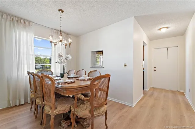a dining room with furniture a chandelier and wooden floor