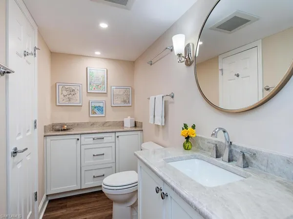 a bathroom with a granite countertop sink a toilet and a mirror