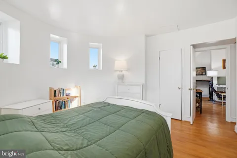 a bedroom with a bed and wooden floor