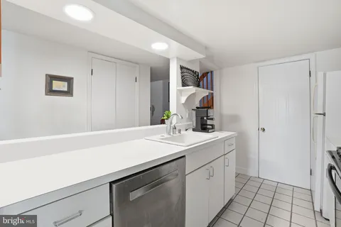 a utility room with a sink a cabinetry and a potted plant