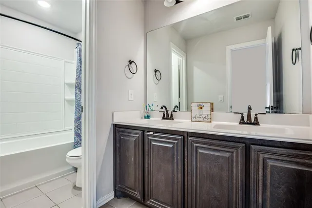 a bathroom with a granite countertop sink a toilet and a large mirror