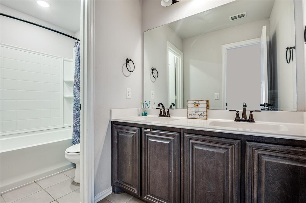 4609 Massey Meadows Way Midlothian, TX 76065 - Photo 23 of 25 a bathroom with a granite countertop sink a toilet and a large mirror