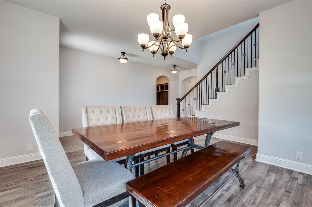 4609 Massey Meadows Way Midlothian, TX 76065 - Photo 4 of 25 a dining room with wooden floor a chandelier a wooden table and chairs