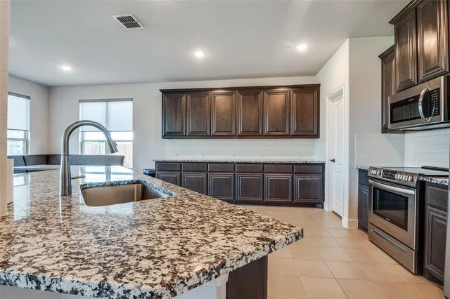 a kitchen with stainless steel appliances granite countertop a stove microwave and sink