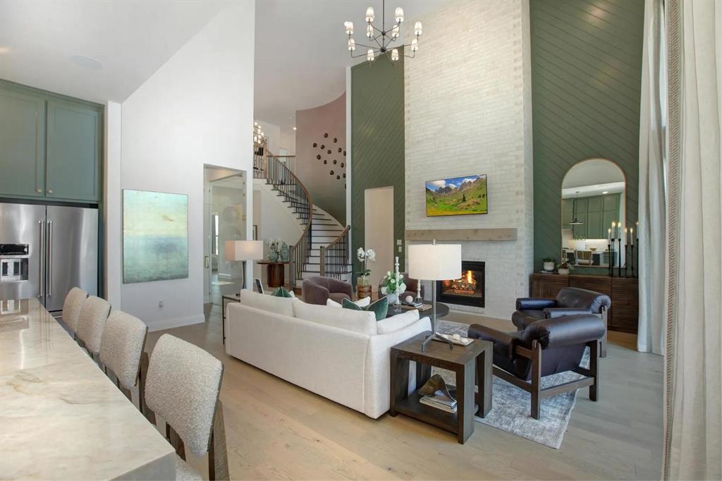 317 Bee Balm Road McKinney, TX 75071 - Photo 3 of 24 a living room with furniture a chandelier and a fireplace