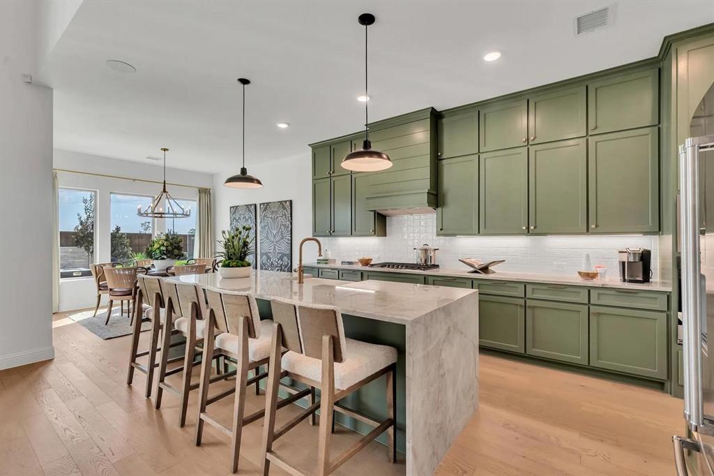 317 Bee Balm Road McKinney, TX 75071 - Photo 5 of 24 a kitchen with a table chairs sink and cabinets
