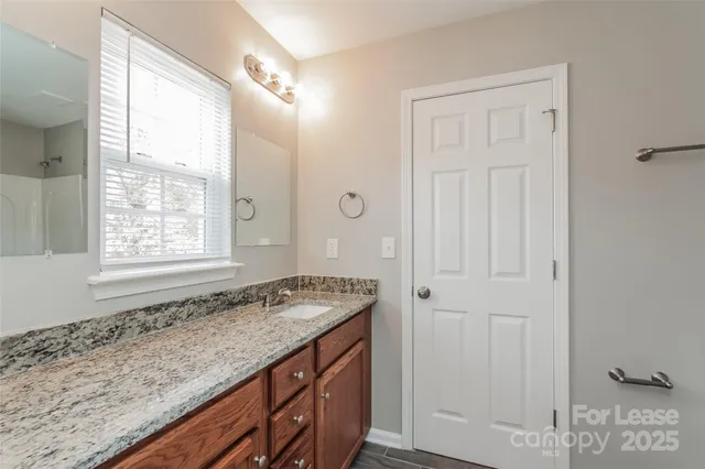 a bathroom with a granite countertop sink and a mirror