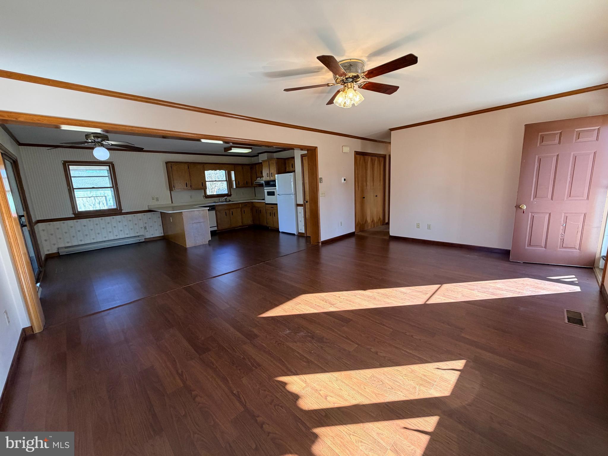 31461 Hope Street Ocean View, DE 19970 - Photo 5 of 20 a view of an empty room with wooden floor and a ceiling fan