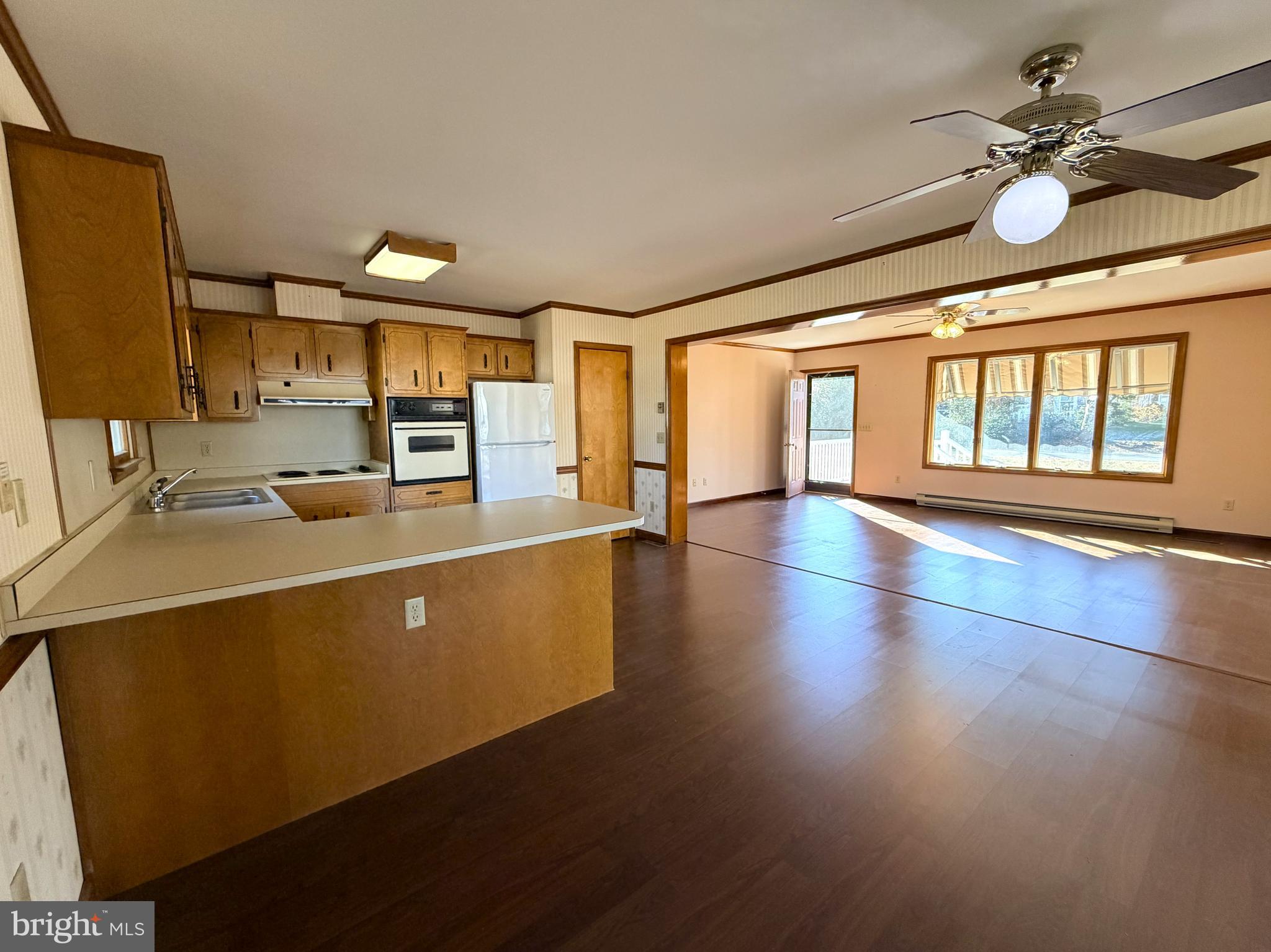 31461 Hope Street Ocean View, DE 19970 - Photo 8 of 20 a open kitchen with stainless steel appliances granite countertop a stove top oven a sink with wooden cabinets and wooden floor