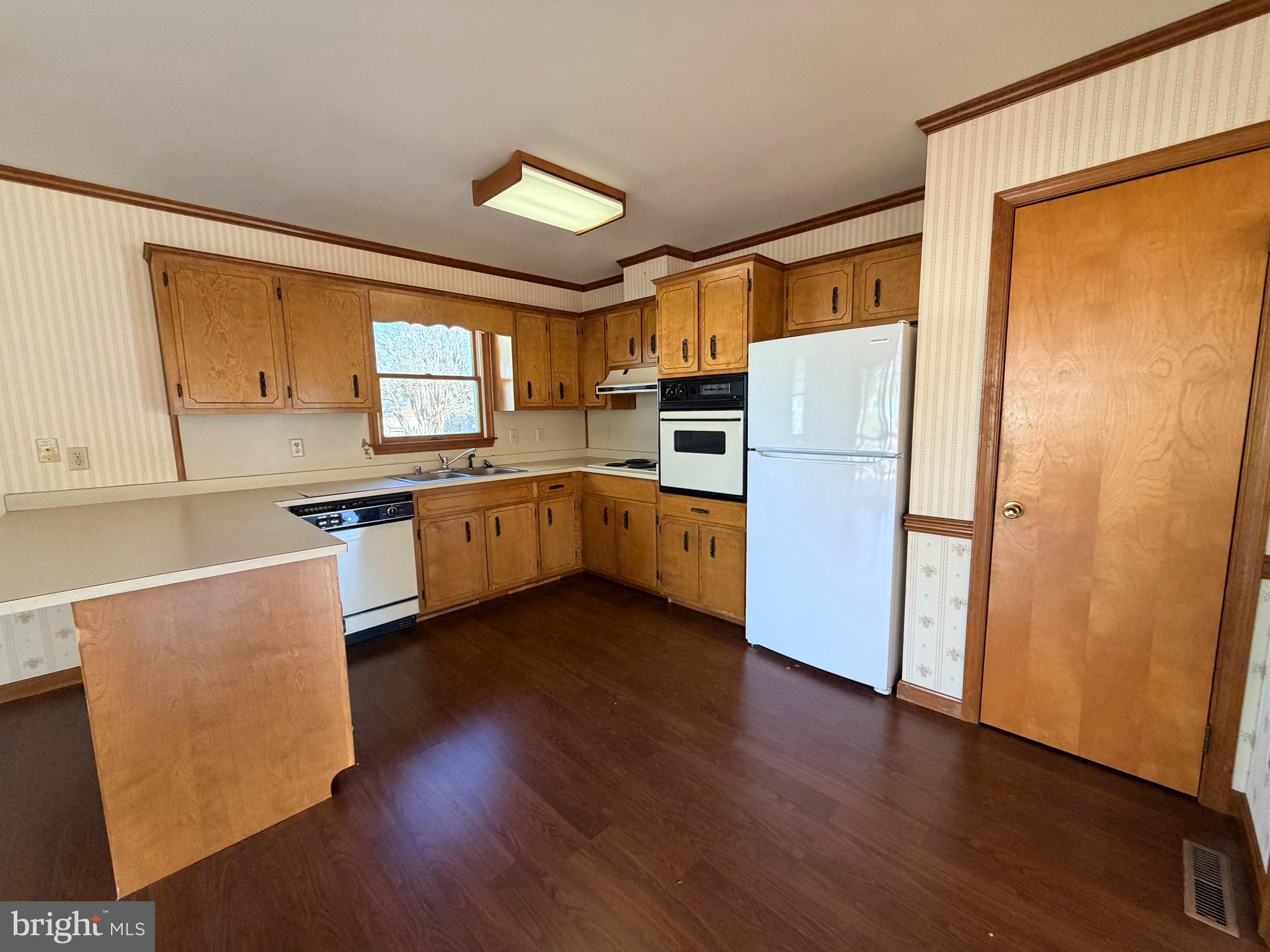 31461 Hope Street Ocean View, DE 19970 - Photo 9 of 20 a kitchen with wooden floors and white appliances