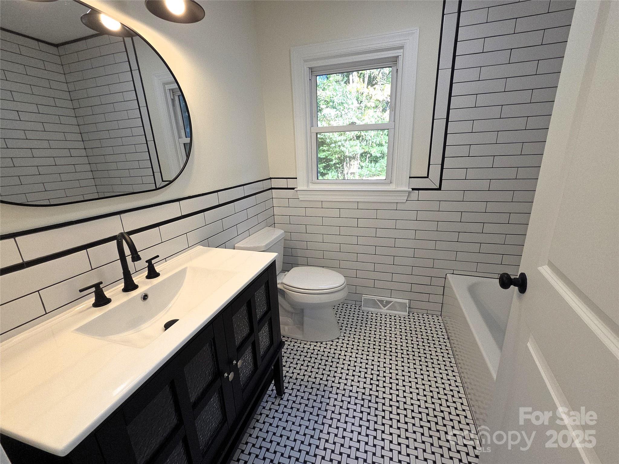 4750 J W Cline Road Kannapolis, NC 28083 - Photo 14 of 16 a bathroom with a sink a toilet a mirror and shower