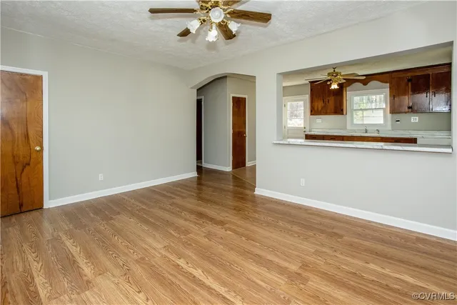 a view of a kitchen with wooden floor and a ceiling fan