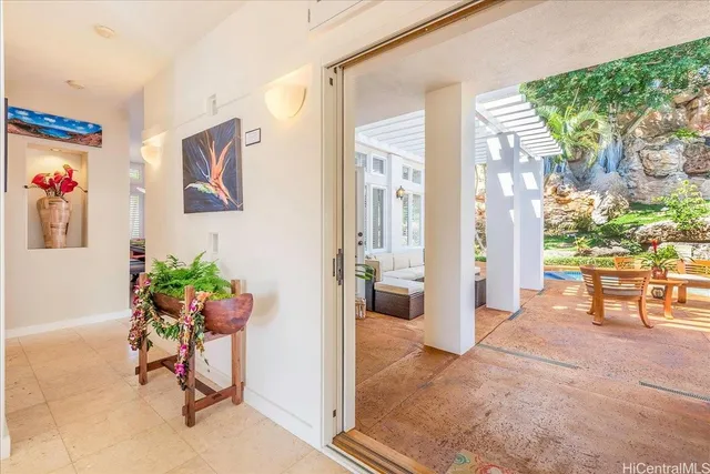 a view of a hallway with a dining table and chairs