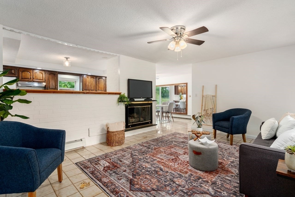 10 Temi Road Chelmsford, MA 01824 - Photo 4 of 22 a living room with furniture a flat screen tv and kitchen view