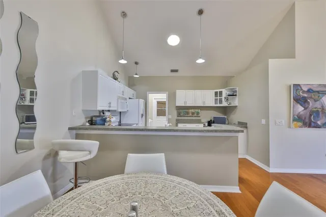 a living room with stainless steel appliances furniture a rug and a kitchen view