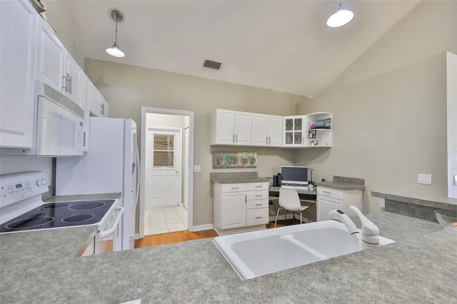 a kitchen that has a lot of cabinets in it and appliances