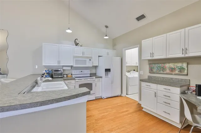 a kitchen with kitchen island a sink stove and refrigerator