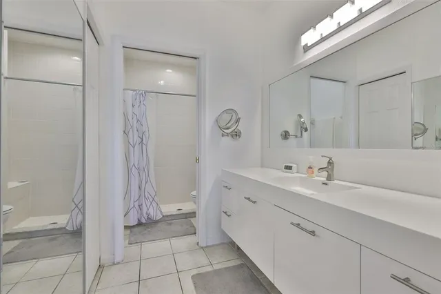 a bathroom with a double vanity sink a toilet and a mirror