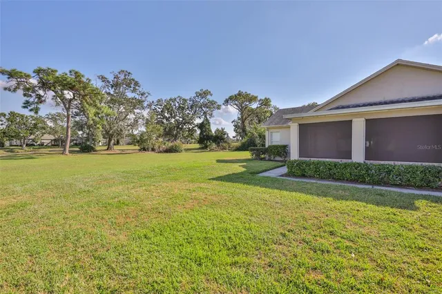 a view of a house with a big yard and palm trees