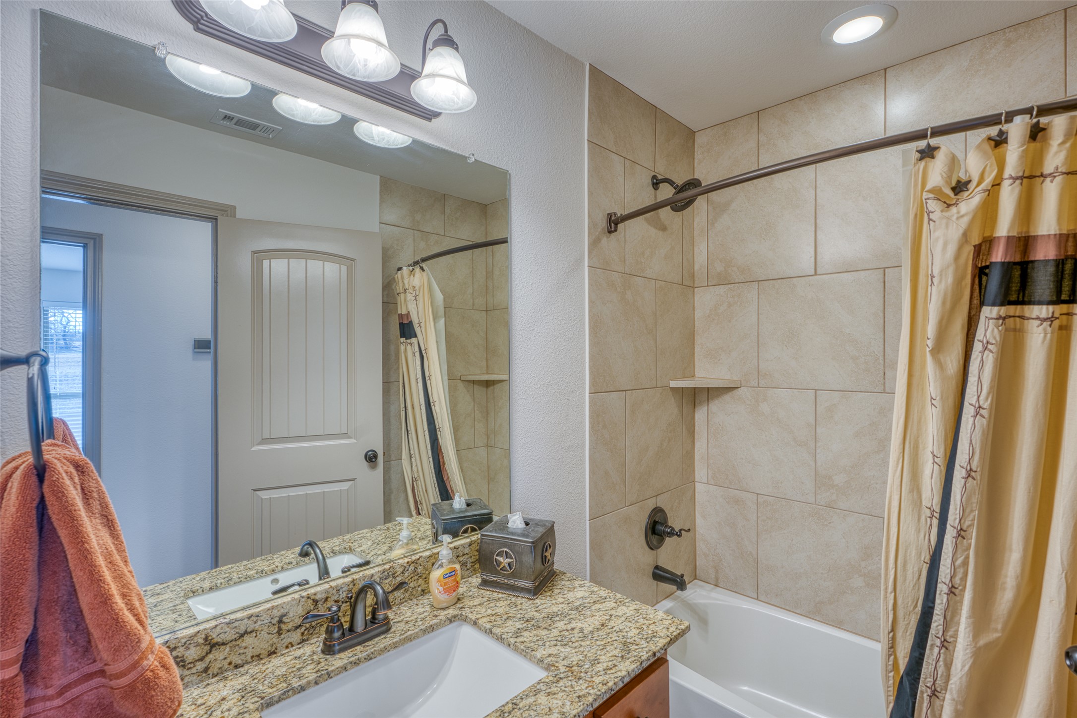 489 Nordic Ridge Road Bertram, TX 78605 - Photo 8 of 19 a bathroom with a granite countertop sink a shower and a mirror