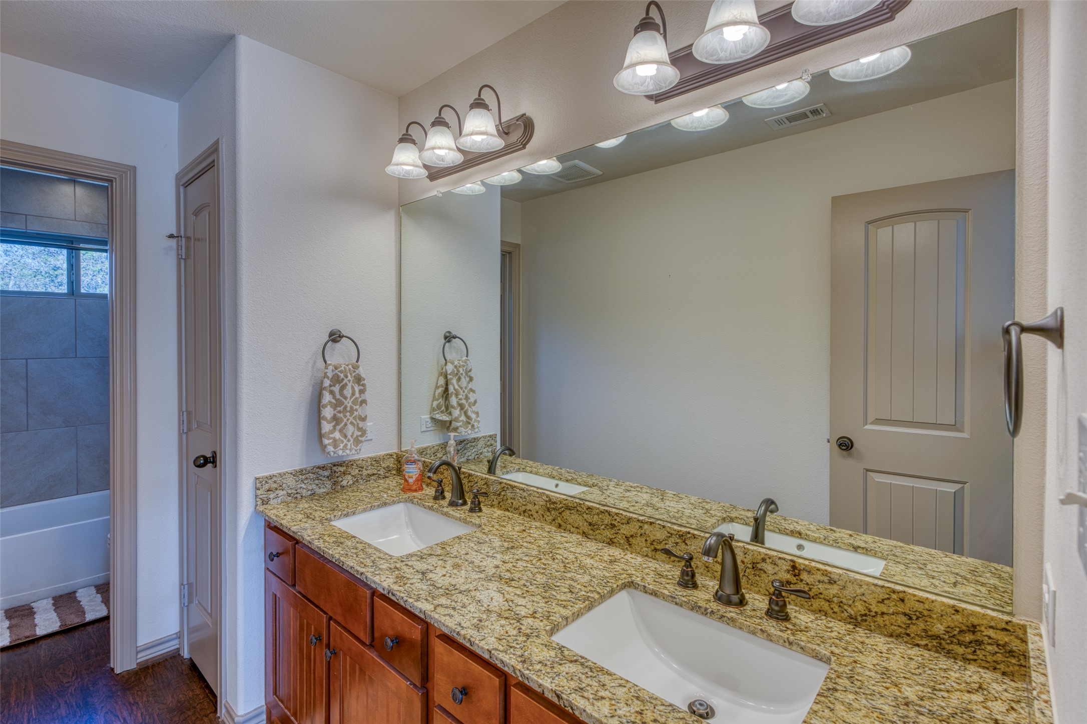 489 Nordic Ridge Road Bertram, TX 78605 - Photo 10 of 19 a bathroom with a granite countertop sink and a mirror