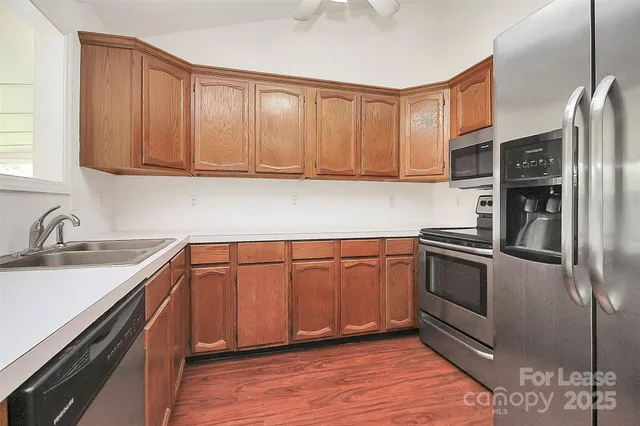 a kitchen with stainless steel appliances granite countertop a sink stove and refrigerator