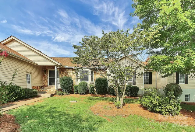 a backyard of a house with table and chairs and potted plants