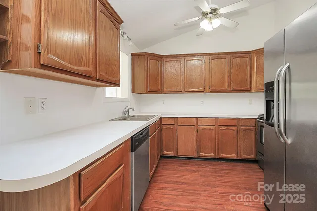 a kitchen with stainless steel appliances granite countertop a sink refrigerator and cabinets