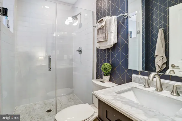 a bathroom with a granite countertop sink a toilet and shower