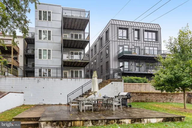 a view of a brick building with many windows and plants
