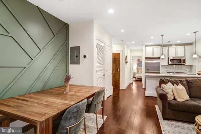 a kitchen with stainless steel appliances granite countertop a refrigerator a stove and a wooden floors