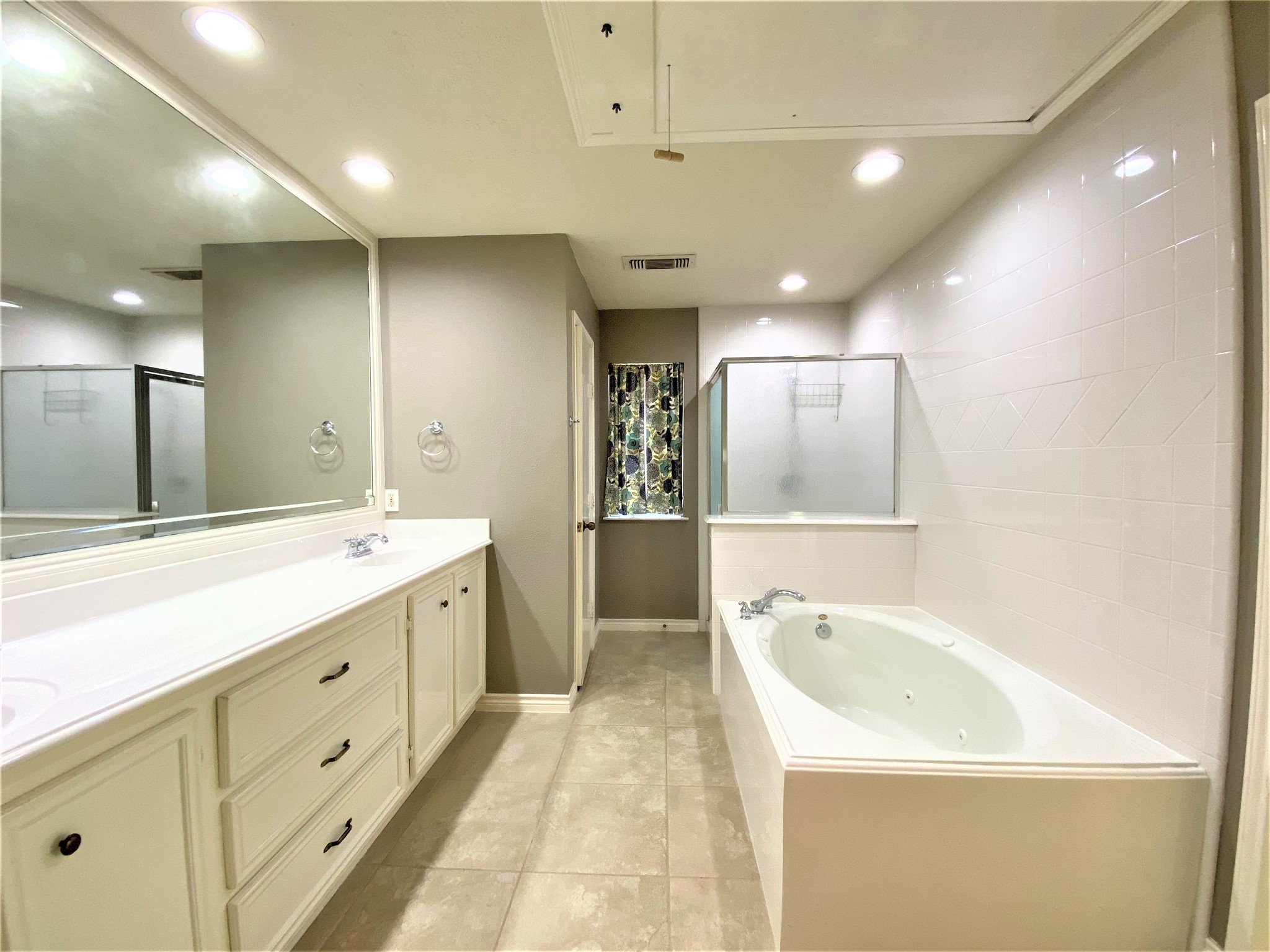 12303 Longfellow Drive Montgomery, TX 77356 - Photo 17 of 26 a bathroom with a bathtub a double vanity sink and mirror