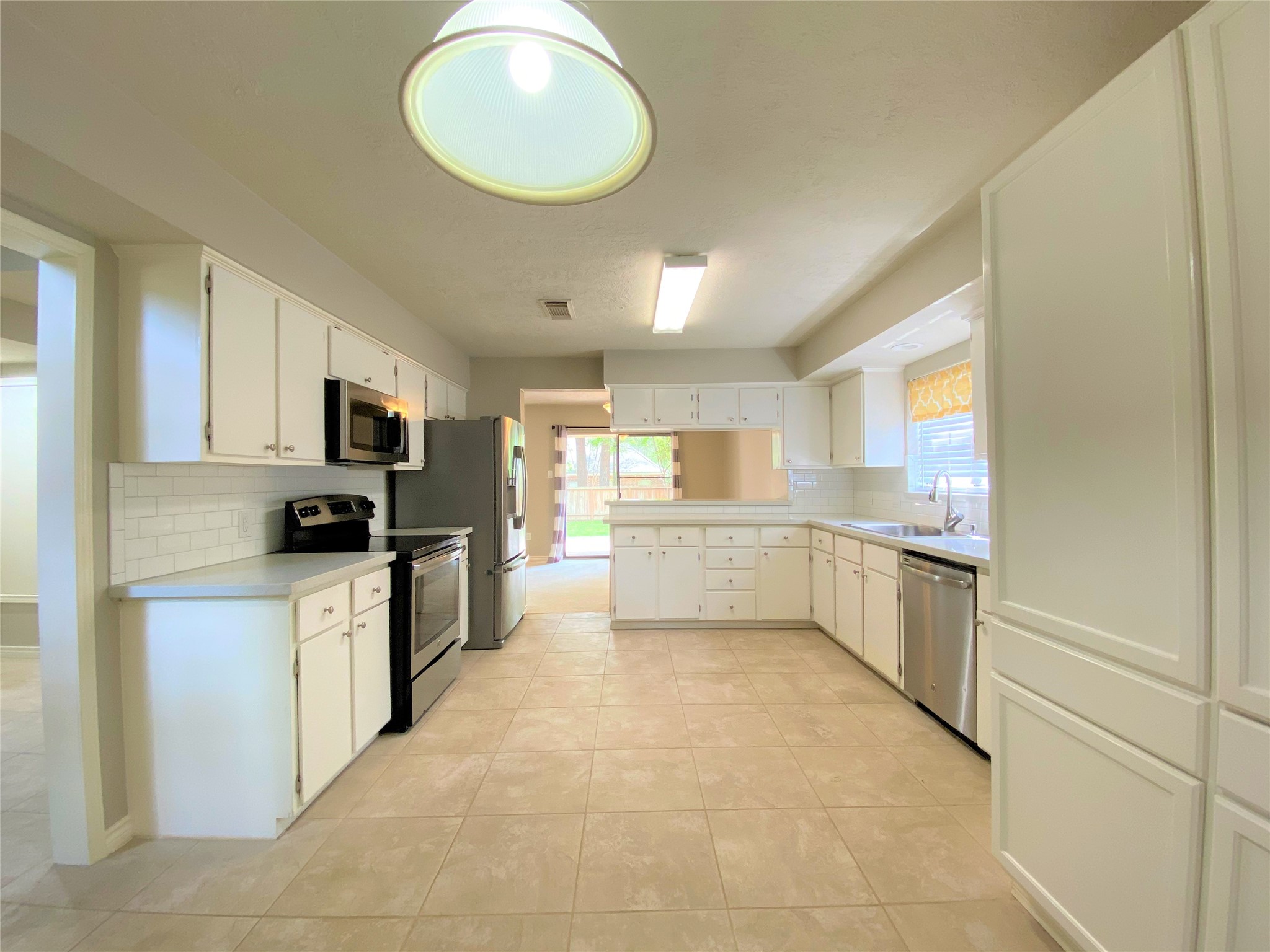 12303 Longfellow Drive Montgomery, TX 77356 - Photo 9 of 26 a kitchen with stainless steel appliances a refrigerator sink and cabinets