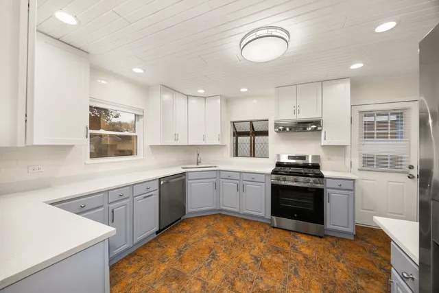 a kitchen with stainless steel appliances granite countertop a stove sink and cabinets
