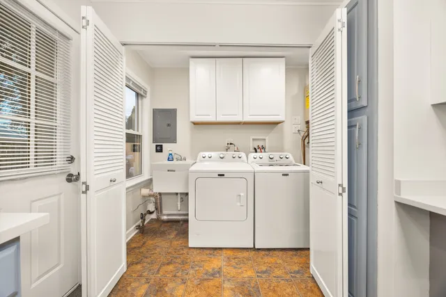 a utility room with cabinets washer and dryer