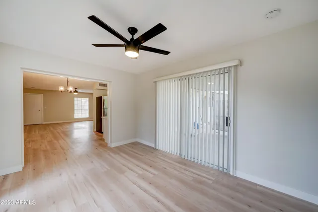 a view of a livingroom with a ceiling fan and wooden floor