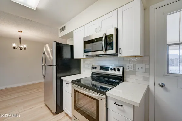 a kitchen with stainless steel appliances a stove microwave and a refrigerator