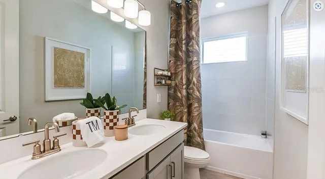 a living room with furniture a flat screen tv and a floor to ceiling window