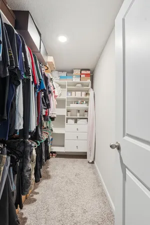 a view of walk in closet with clothes and shoes