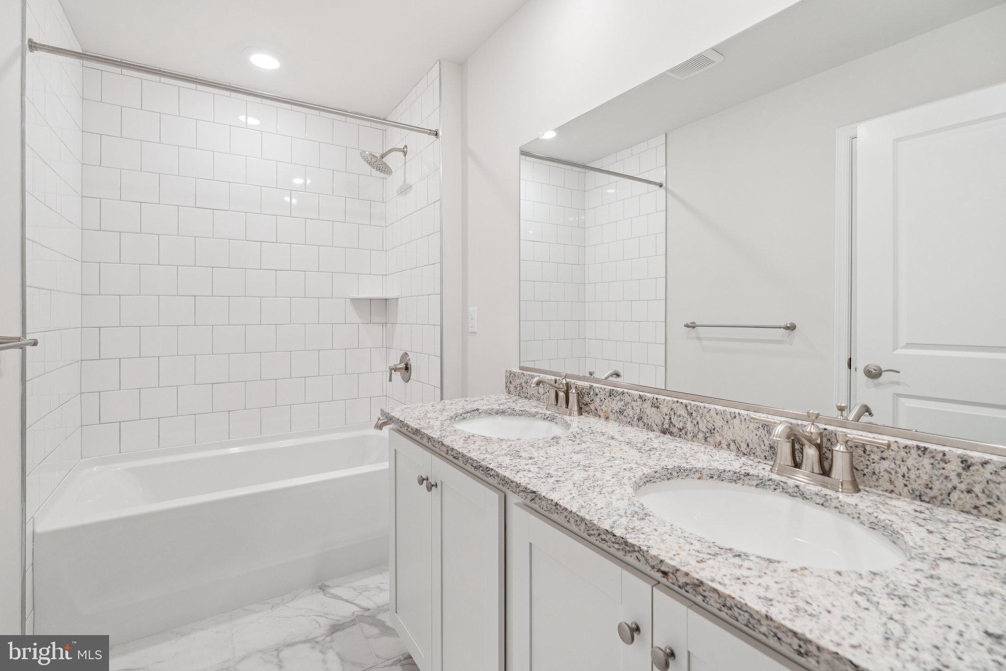 6278 Sterling Way Ruther Glen, VA 22546 - Photo 18 of 32 a bathroom with a granite countertop double vanity sink and mirror with bathtub