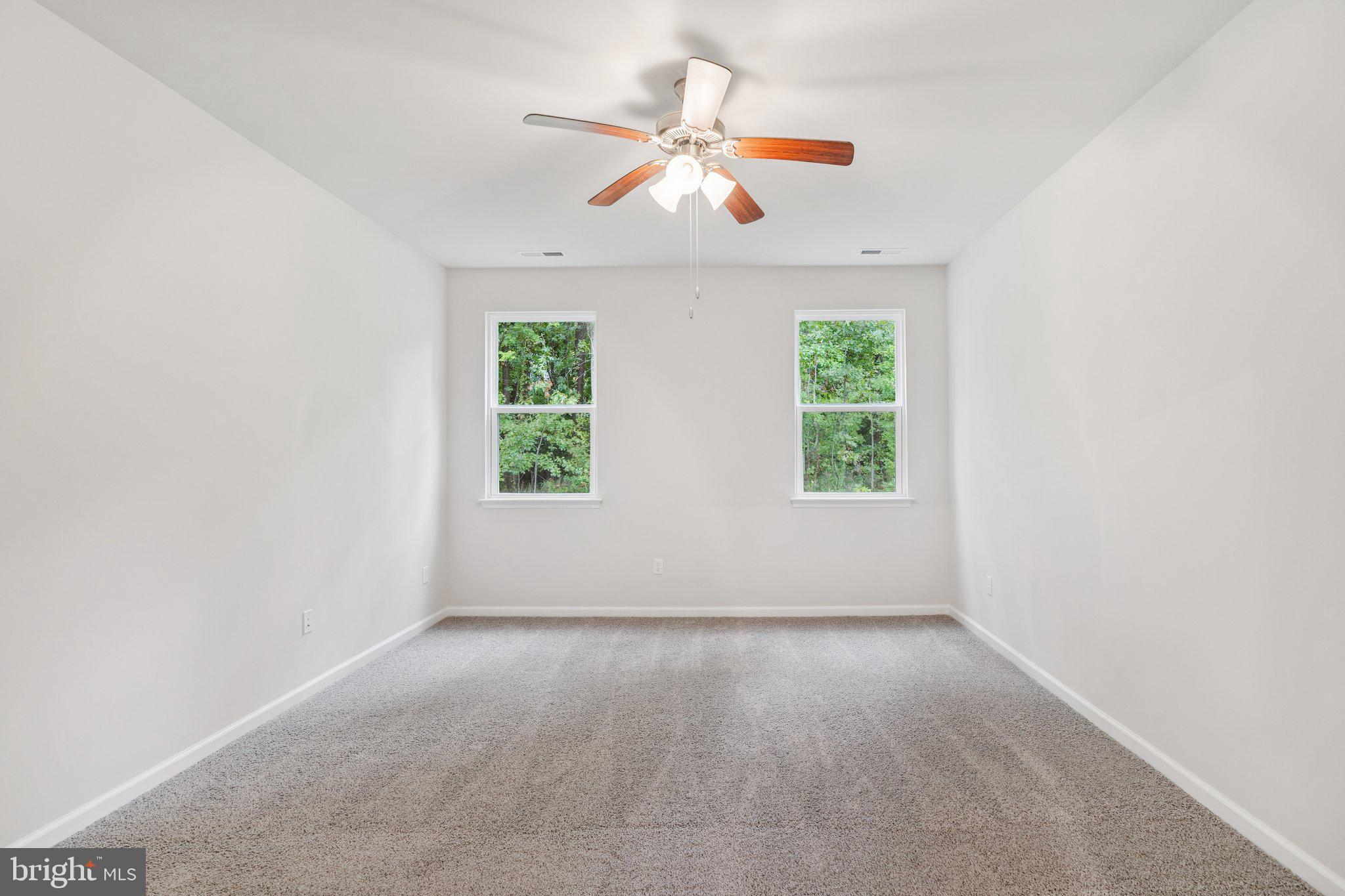 6278 Sterling Way Ruther Glen, VA 22546 - Photo 27 of 32 an empty room with windows and ceiling fan