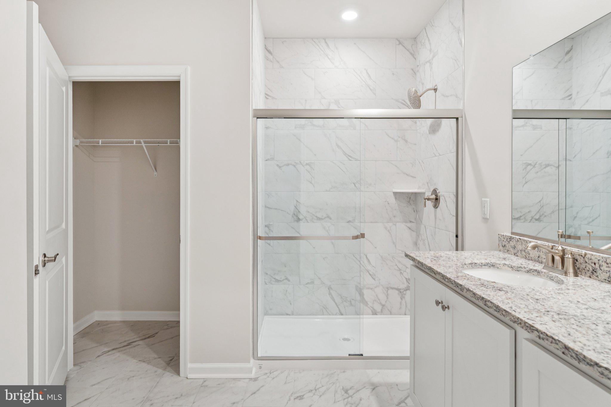 6278 Sterling Way Ruther Glen, VA 22546 - Photo 30 of 32 a bathroom with a granite countertop sink a shower and a mirror