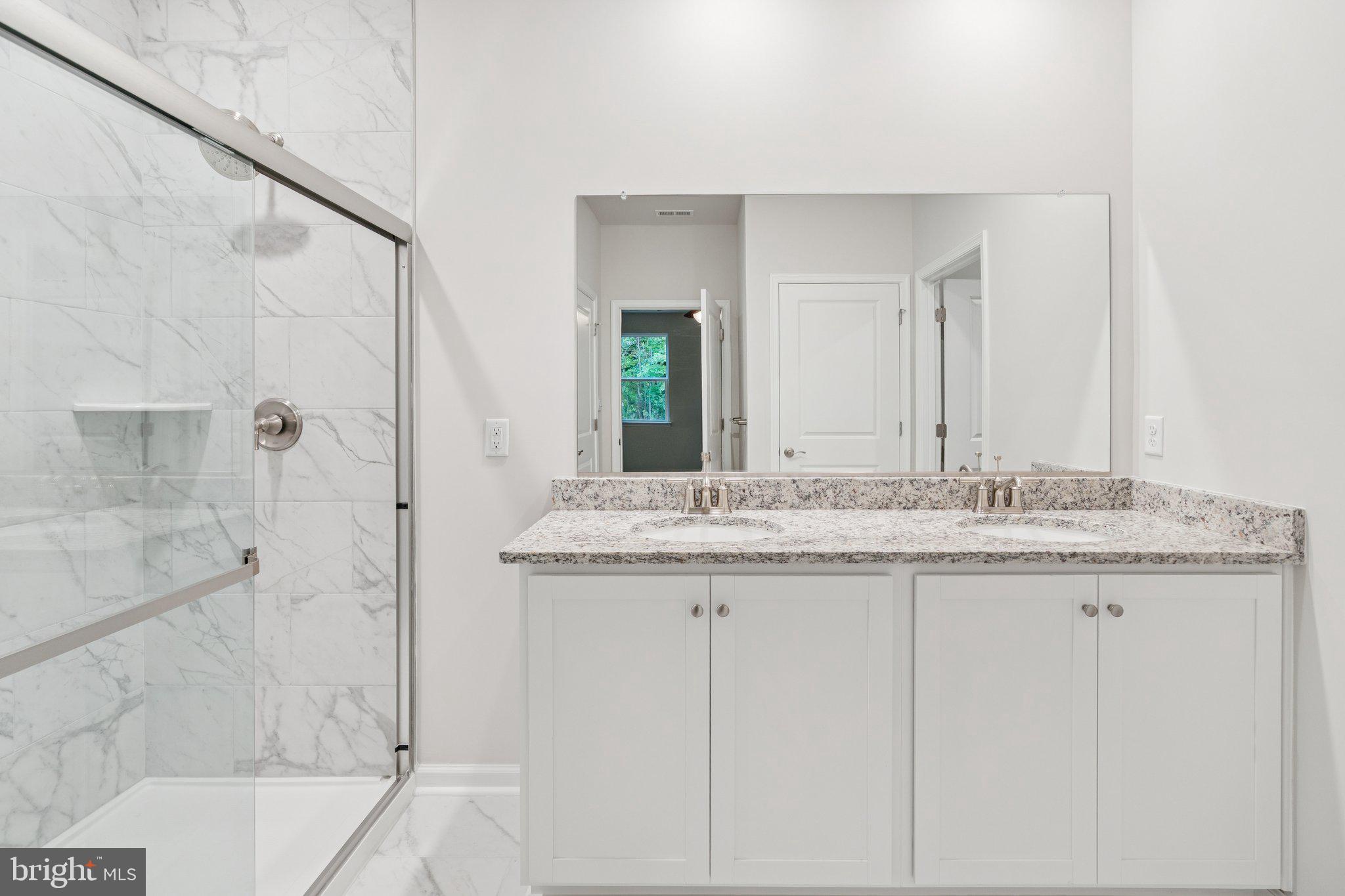 6278 Sterling Way Ruther Glen, VA 22546 - Photo 31 of 32 a bathroom with a granite countertop sink two mirror and shower