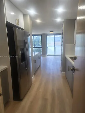 a view of a refrigerator in kitchen and a window