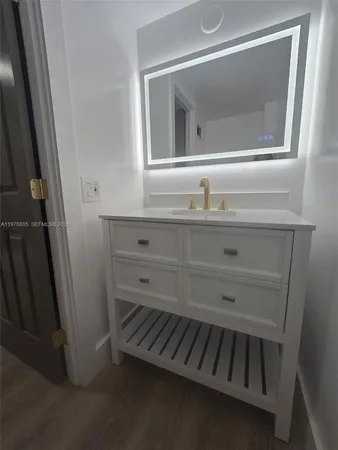 a bathroom with a sink a mirror and vanity